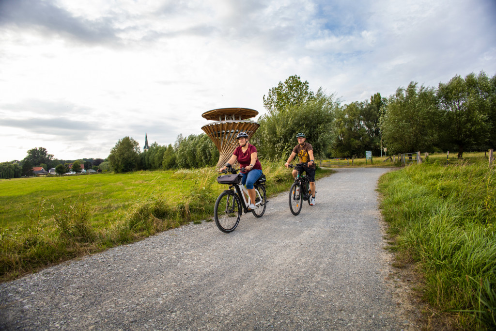 Photo of two people on a bike riding in nature
